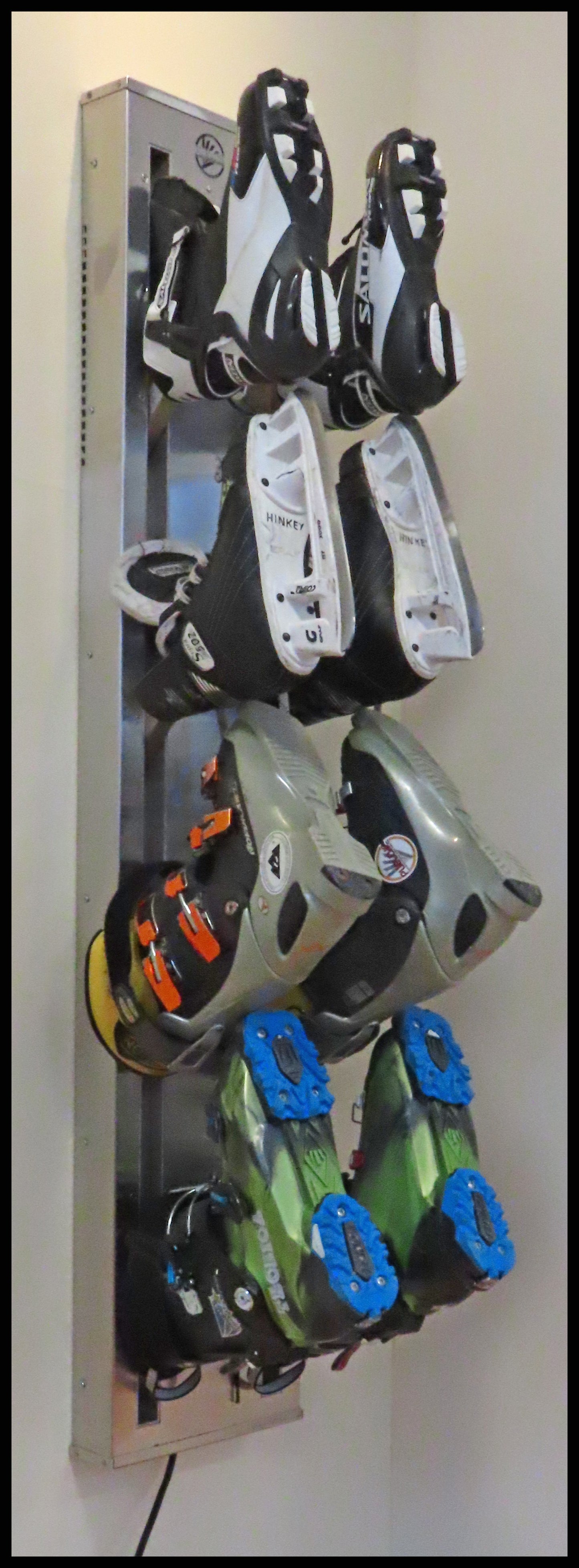 Wall mounted Boot Dryer wall mount. Four pair stainless steel. Warm or ambient air. Attractive space saving design best for ski homes , condos and any mudroom. Timer controlled dryer for ski boots, skates, gloves. Shown with skates, ski boots and xc ski boots. From Puelche dryer